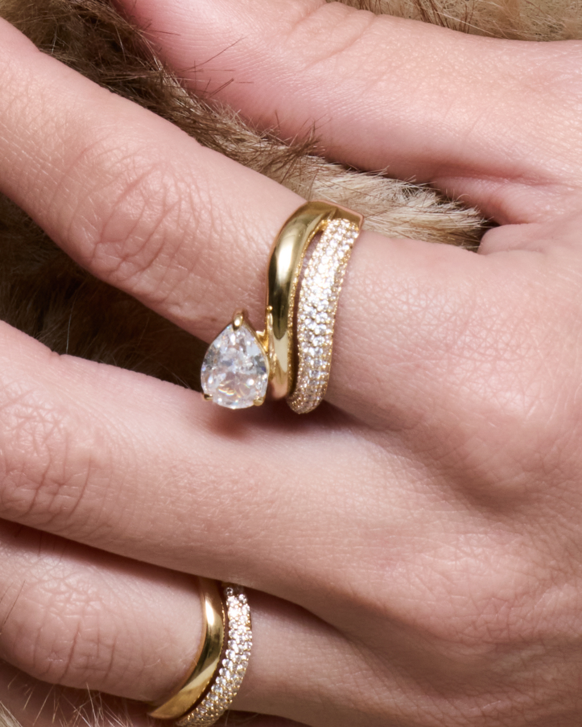 Bague Signature dorée en argent 925 plaqué or 3 microns, design double anneau – l’un lisse et l’autre serti de zirconiums – surmonté d’une pierre taille poire scintillante, bijou moderne et élégant qui capte la lumière et sublime la main.