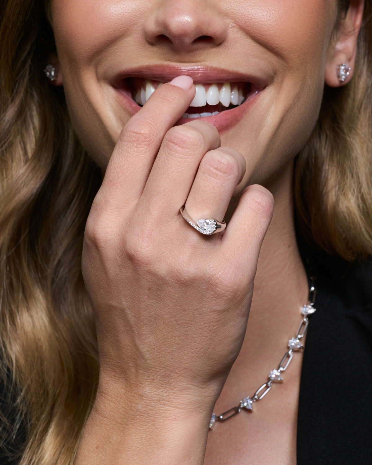 Bague Pear Glow blanche en argent 925 rhodié avec pierre centrale en zirconium taille poire entourée d’un délicat pavage de zirconiums, design fluide et asymétrique qui épouse le doigt pour un éclat subtil et raffiné.