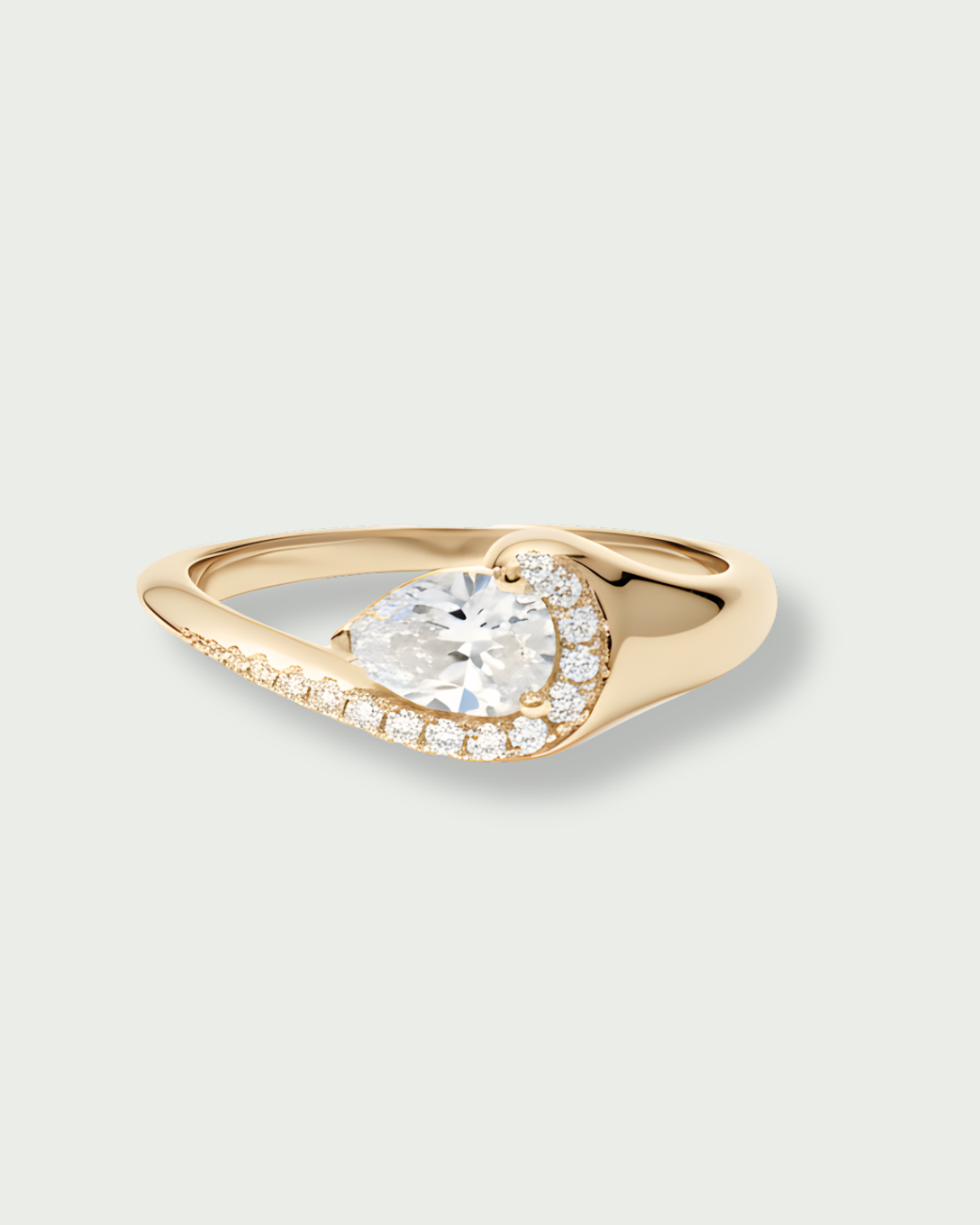Bague « Pear Glow » en argent 925 rhodié, pierre centrale en zirconium taille poire entourée d’un délicat pavage de zirconiums, anneau légèrement torsadé à la finition polie brillante.