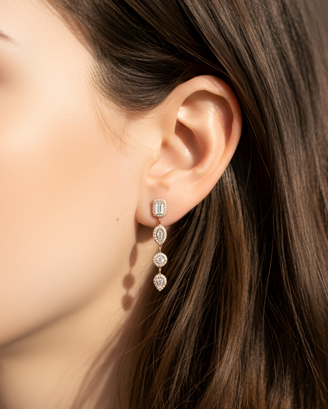 Boucles d’oreilles « Gabriella » en argent 925 doré à l’or rose 18 carats, ornées de pierres en zirconium alternant tailles ronde, poire, marquise et radiant, longueur 34,5 mm, largeur 5 mm.