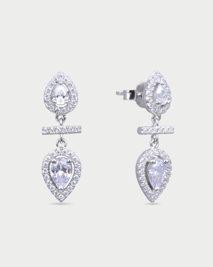 Boucles d’oreilles « Opposite Infini Poire » en argent 925 rhodié, deux zircons blancs taille poire montés en symétrie miroir, séparés par une petite barre sertie, finition polie brillante.