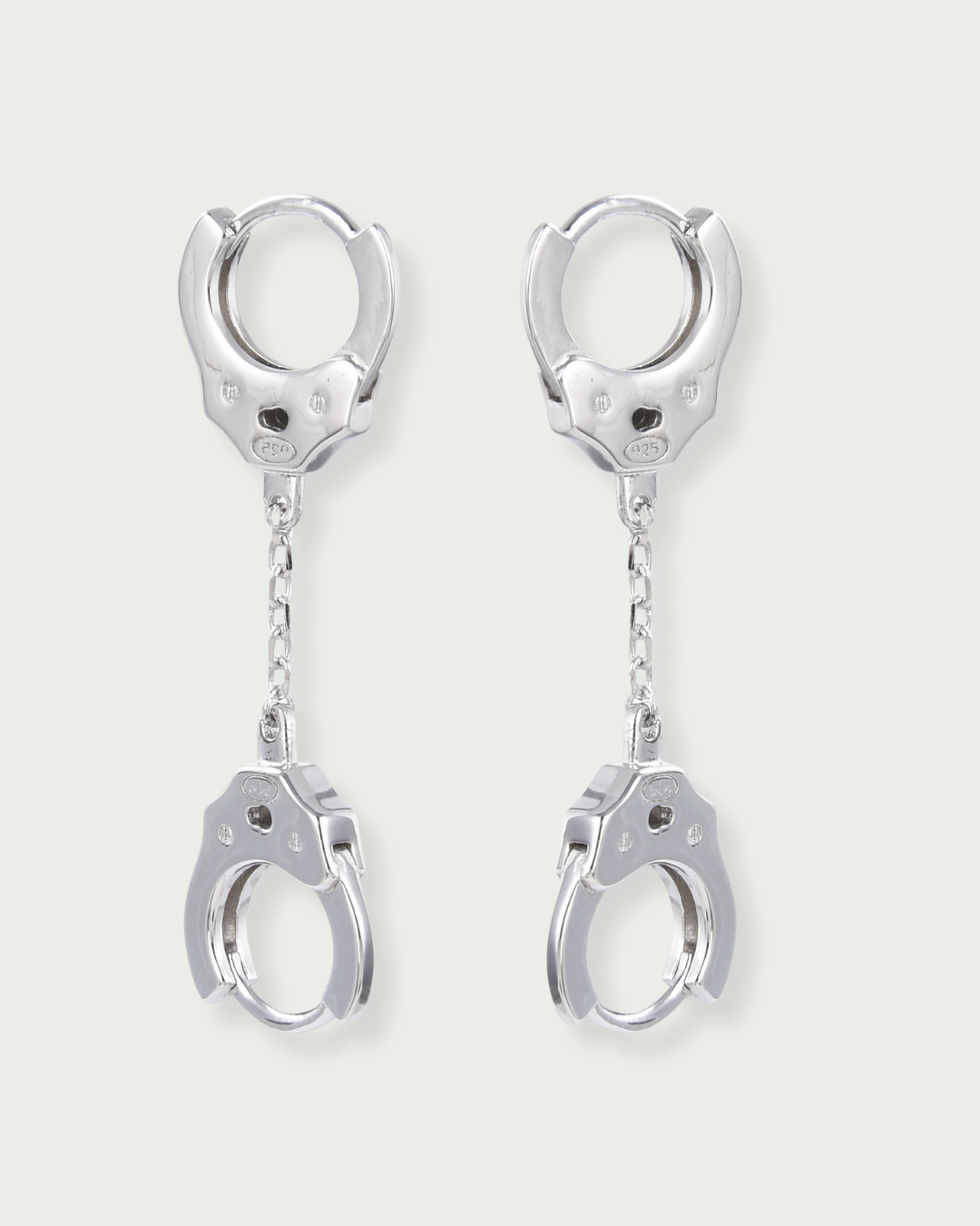 Boucles « Menottes » en argent 925 rhodié, deux anneaux reliés par un maillon central, design moderne et lumineux.