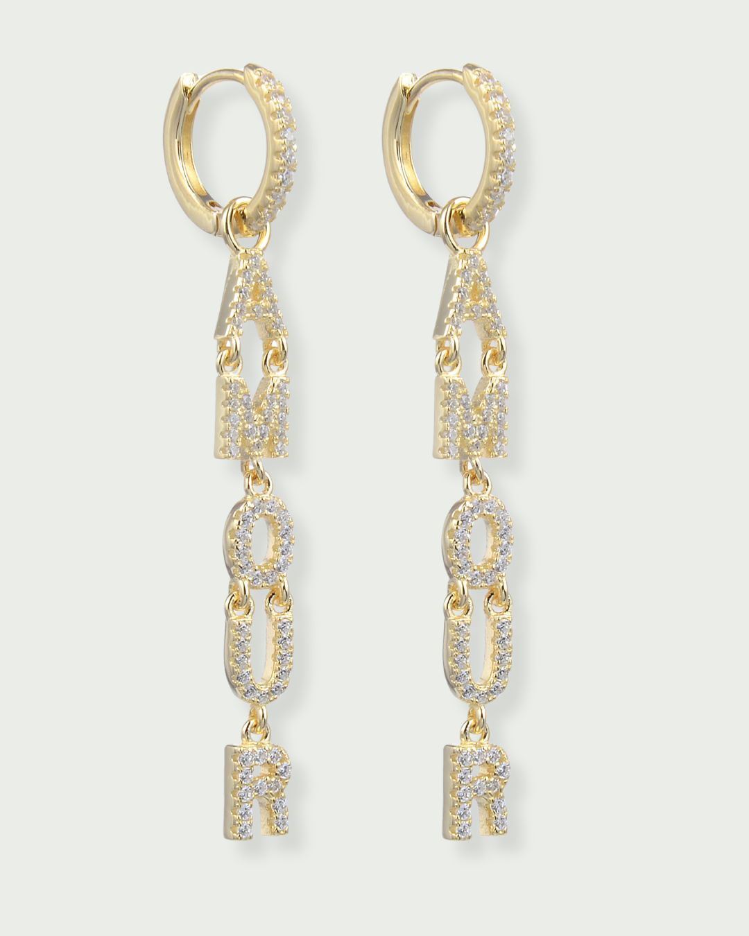 Boucles d’oreilles pendantes « Amour » en argent 925 doré à l’or fin 18 carats, lettres serties de zirconiums formant le mot AMOUR suspendues à un anneau, finition polie brillante.