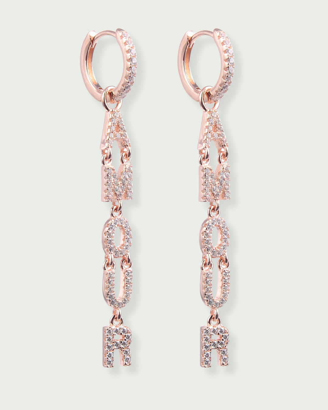 Boucles d’oreilles pendantes « Amour » en argent 925 doré à l’or rose 18 carats, lettres serties de zirconiums formant le mot AMOUR suspendues à un anneau, finition polie brillante.