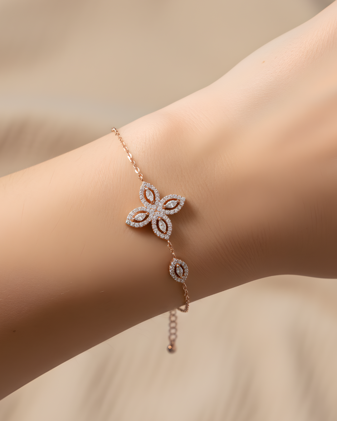 Bracelet « Fleur de Vie » en argent 925 doré à l’or rose 18 carats, motif central composé de quatre pierres en zirconium taille marquise formant une fleur, chaîne ajustable 15 + 3 cm, finition polie brillante.