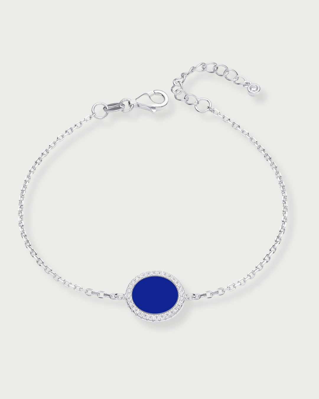 Bracelet en argent 925 rhodié, orné d’une petite médaille ronde sertie d’une pierre lapis-lazuli, finition polie brillante.