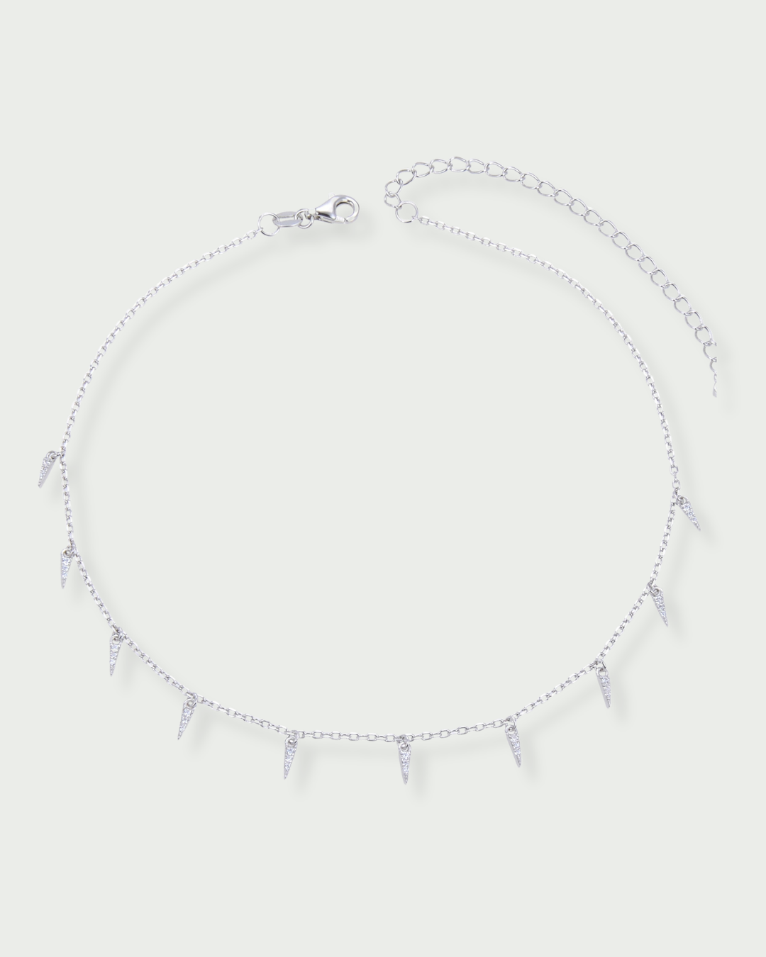Choker en argent 925 rhodié, chaîne fine et pampilles géométrique serties, rendu moderne et lumineux.