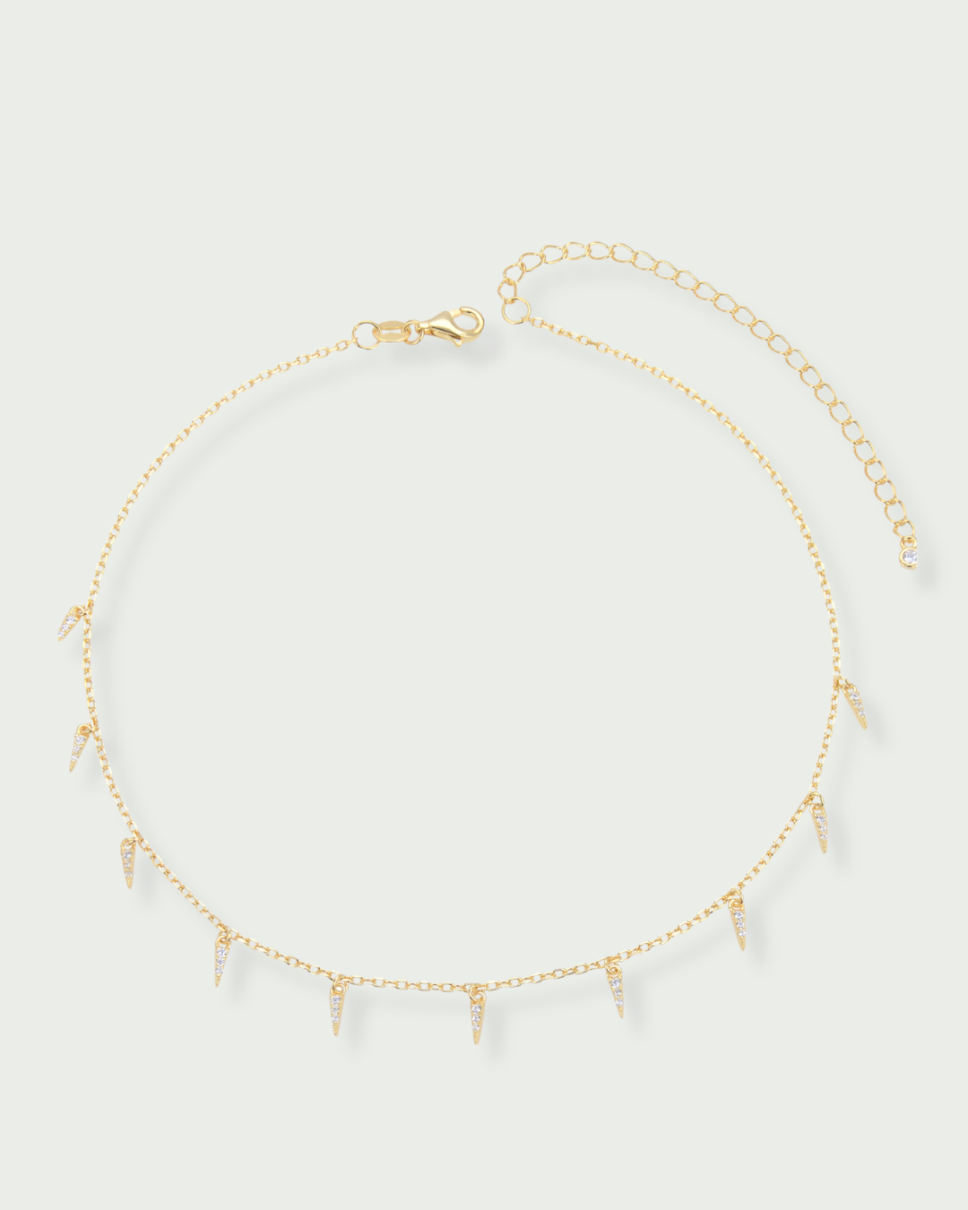 Choker doré en argent 925 doré à l'or 18 carats, chaîne fine et pampilles géométrique serties, rendu moderne et lumineux.