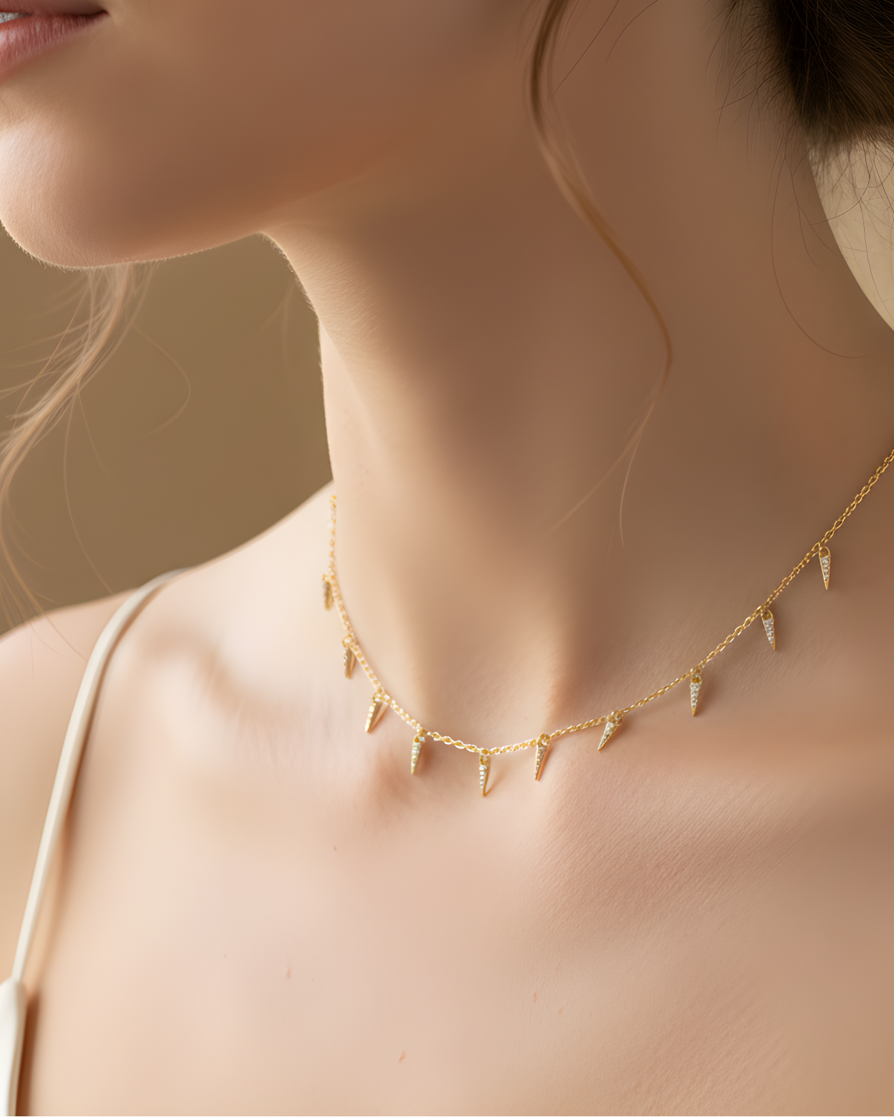 Choker doré en argent 925 doré à l'or 18 carats, chaîne fine et pampilles géométrique serties, rendu moderne et lumineux.