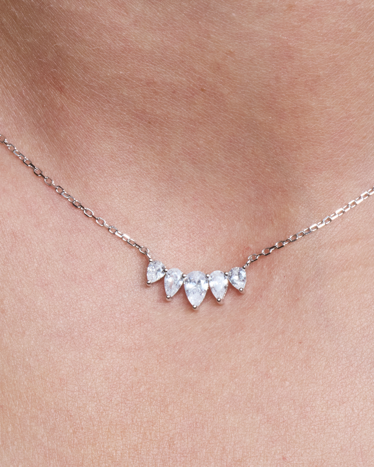 Collier Pear Glow blanc en argent 925 rhodié, chaîne fine avec pendentif composé de cinq zirconiums taille poire délicatement alignés, design lumineux et raffiné qui sublime le décolleté.