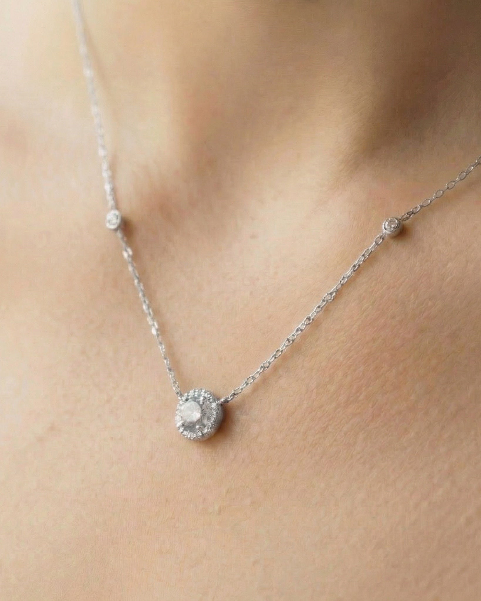 Collier « Collier Infini Rond ‑ Blanc » en argent 925 rhodié, pendentif rond orné d’une pierre zirconium centrale taille brillant, chaîne 40 cm (+6 cm réglable), finition polie brillante.