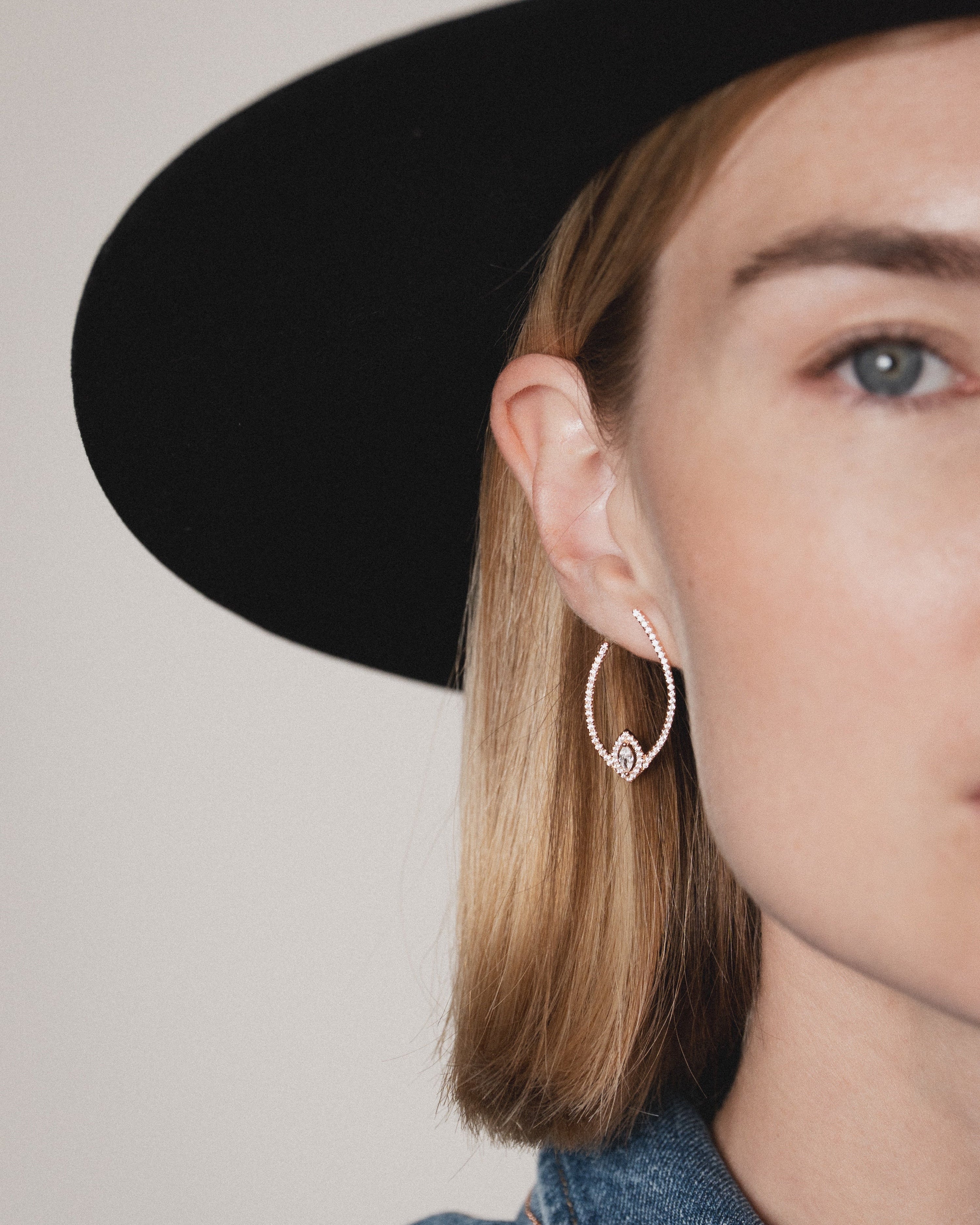 Boucles d’oreilles créoles « Goutte Fleur de Vie » en argent 925 doré à l’or rose 18 carats, forme goutte revisitée avec un motif floral en zirconiums taille marquise, finition polie brillante.