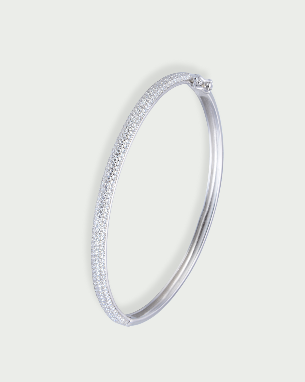 Jonc Pavé Shape blanc en argent 925 rhodié, orné d’un pavage délicat de zirconiums scintillants sur une surface incurvée, design élégant et moderne qui capture la lumière.