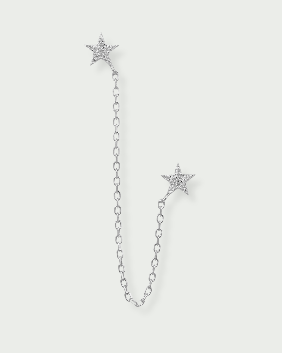 Monoboucle en argent 925 rhodié, deux puces étoiles pavées clos relié par une chaîne fine, finition polie brillante.