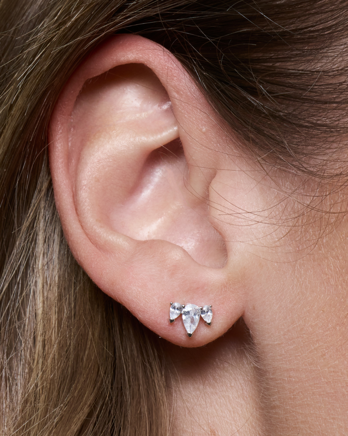 Puces d’oreilles Queen Pear Glow blanches en argent 925 rhodié ornées d’un trio de zirconiums taille poire formant une petite couronne scintillante, design élégant et lumineux qui sublime le lobe.