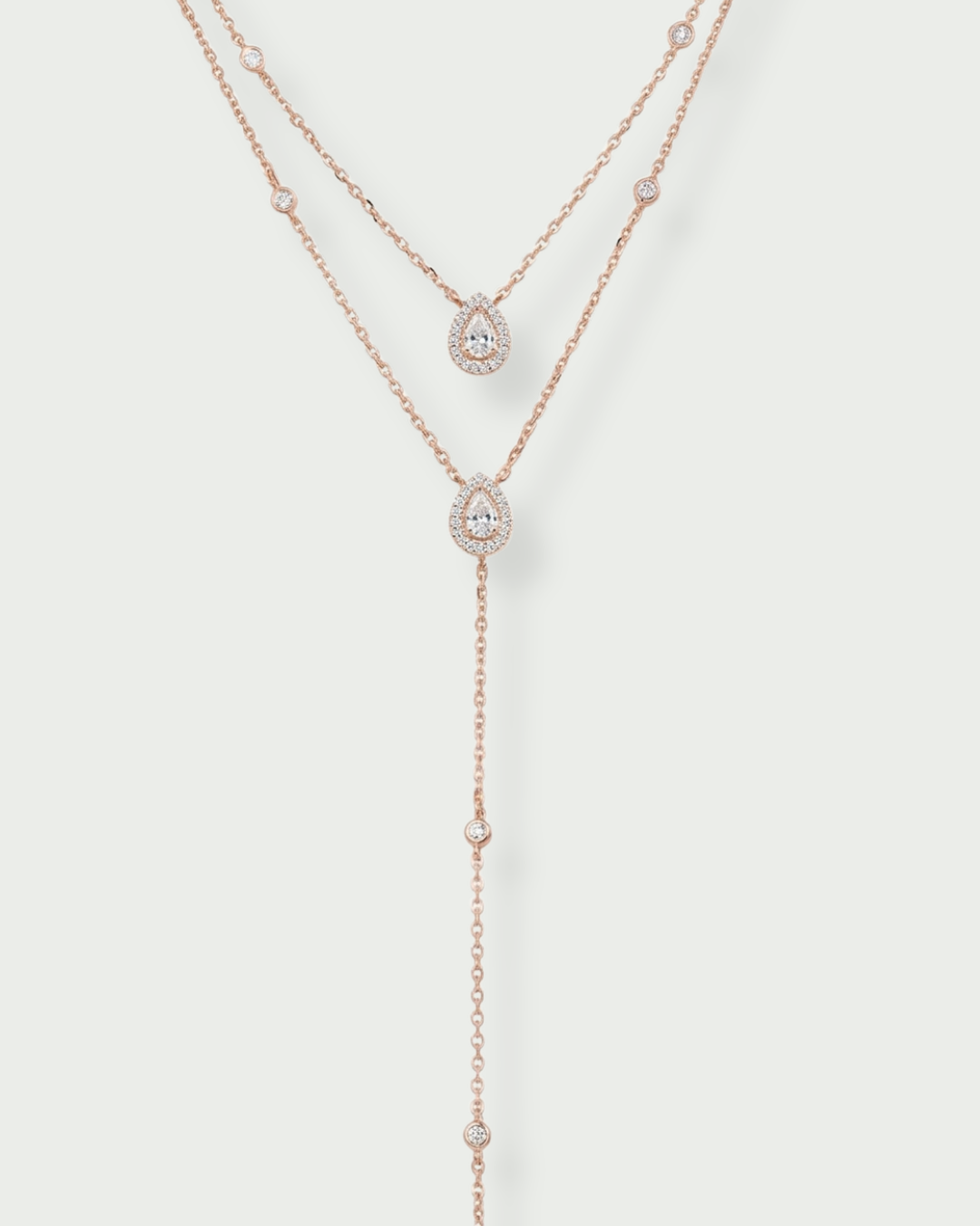 Sautoir « Double Infini Poire » en argent 925 doré à l’or rose 18 carats, double rang dont un rang choker orné de pierres en zirconium taille poire, finition polie brillante.