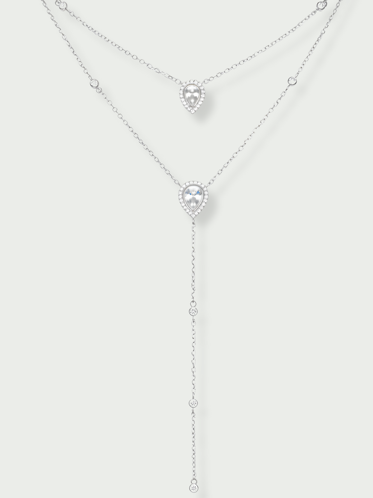 Sautoir double Signature blanc en argent 925 rhodié avec deux chaînes délicates ornées de pendentifs en zirconium taille poire, silhouette en Y élégante et lumineuse qui met en valeur le décolleté avec finesse et sophistication.