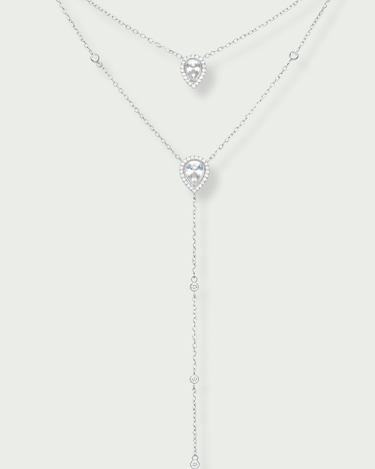 Sautoir double Signature blanc en argent 925 rhodié avec deux chaînes délicates ornées de pendentifs en zirconium taille poire, silhouette en Y élégante et lumineuse qui met en valeur le décolleté avec finesse et sophistication.