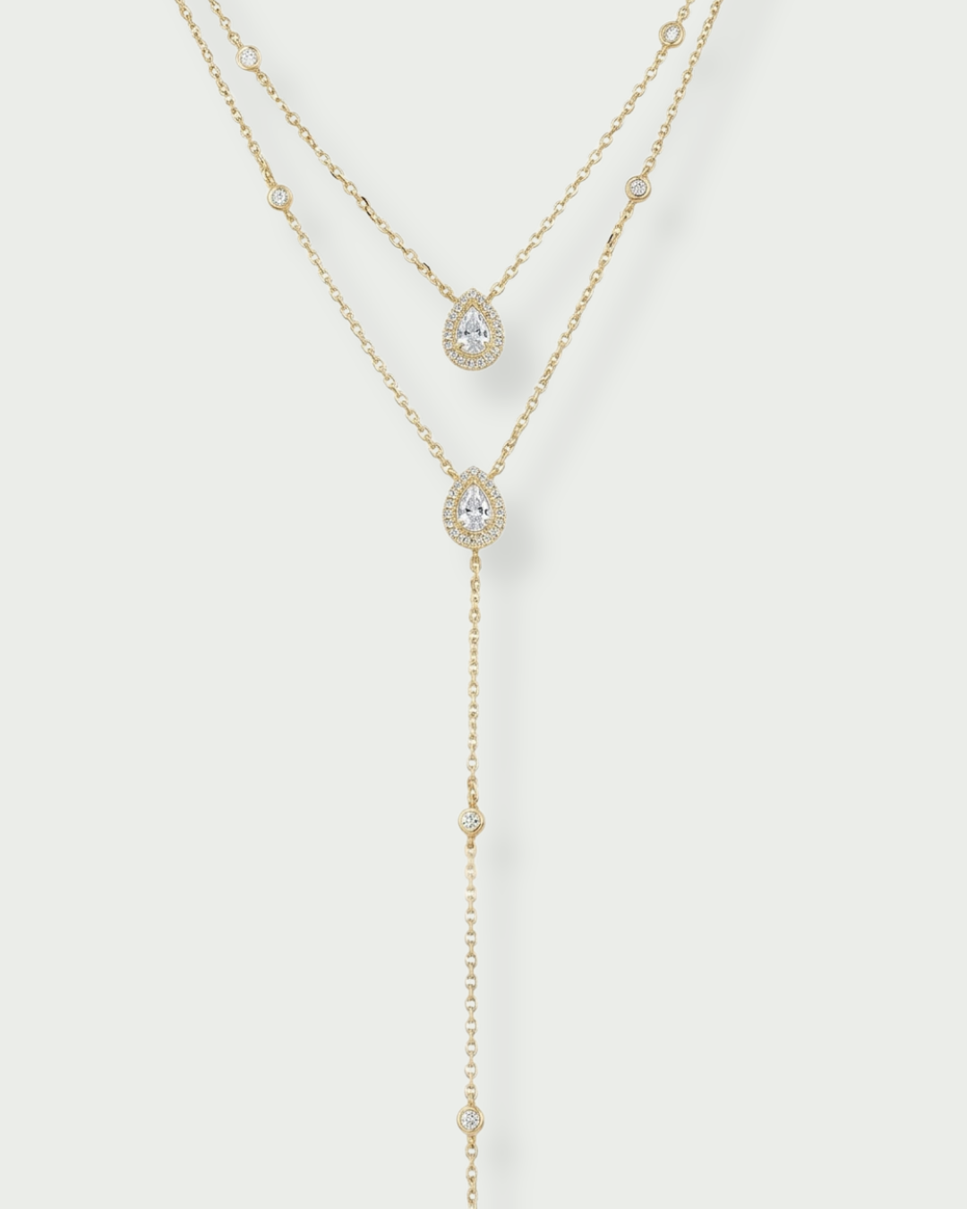 Sautoir « Double Infini Poire » en argent 925 doré à l’or jaune 18 carats, double rang dont un choker orné de pierres en zirconium taille poire, finition polie brillante.