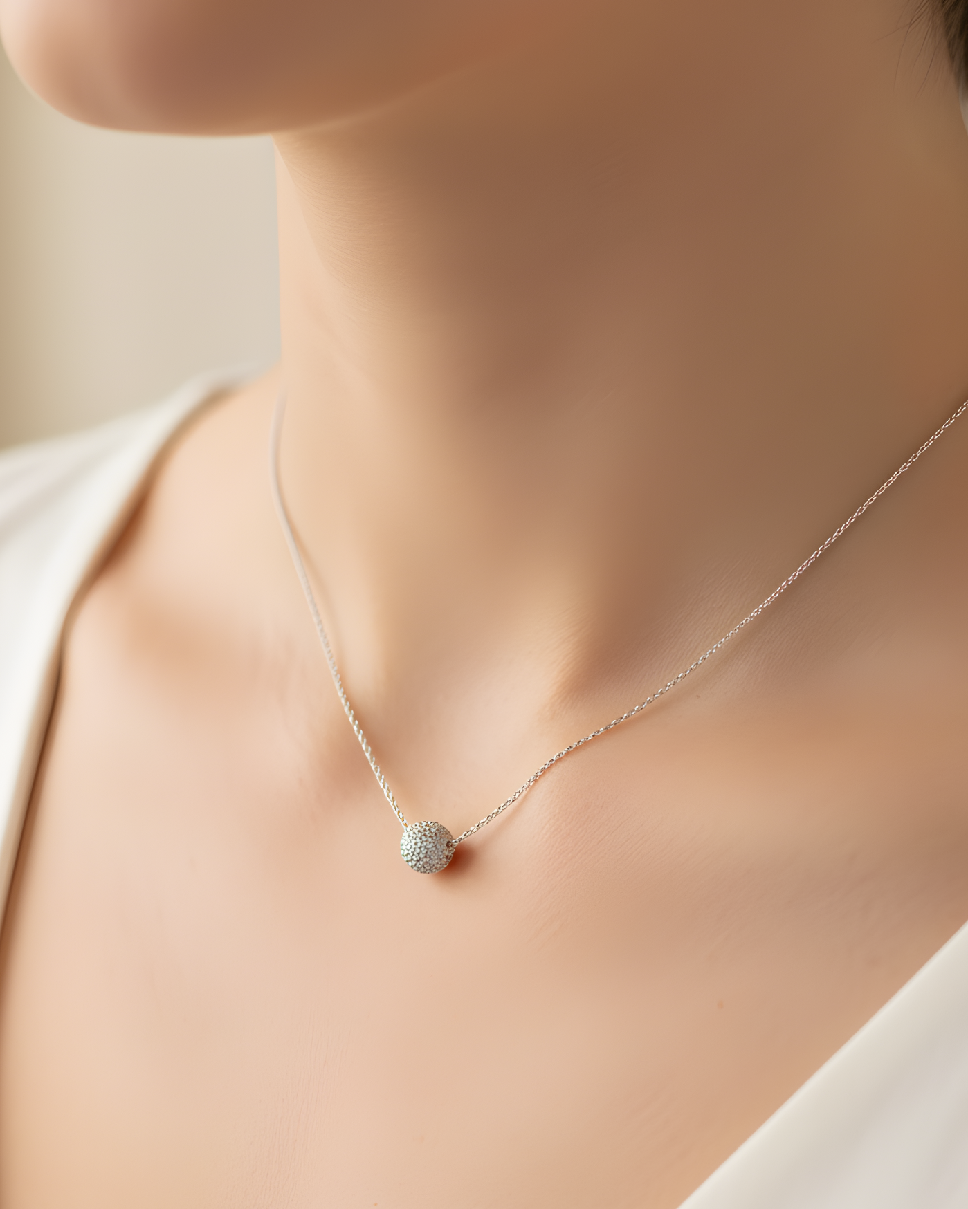 Collier « Atlas » en argent 925 rhodié, pendentif composé d’une boule pavée de zirconiums blancs, chaine torsadée.