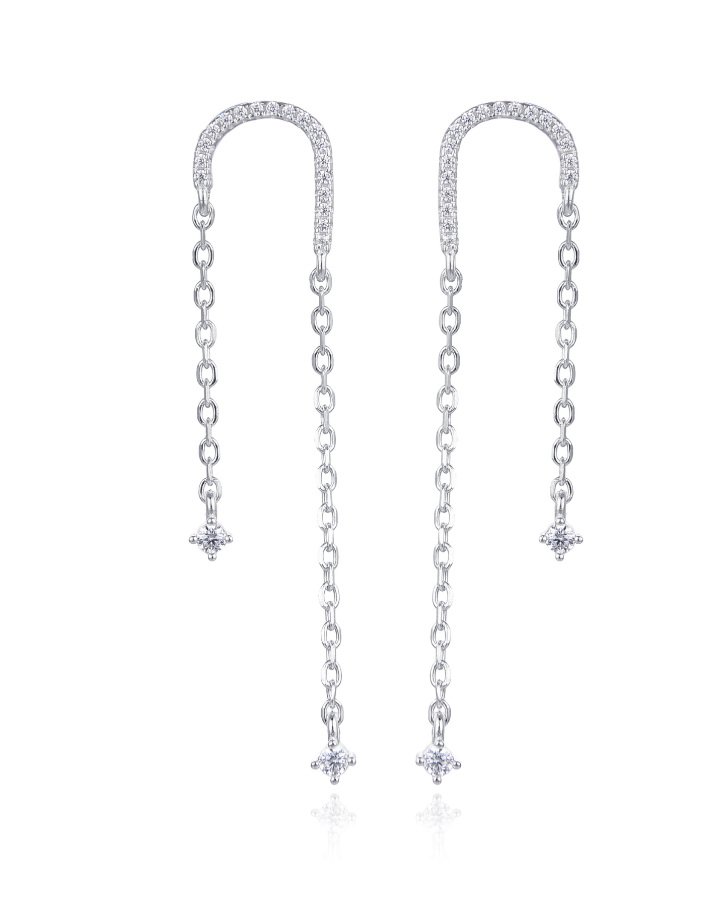 Boucles asymétriques en argent 925 rhodié, arc pavé de zirconiums et fines chaînes terminées par des pendants en pierres blanches.