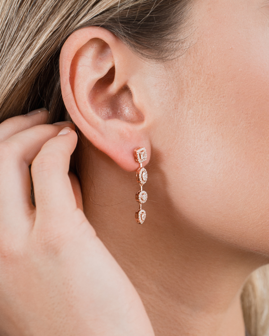 Boucles d’oreilles « Gabriella » en argent 925 doré à l’or rose 18 carats, ornées de pierres en zirconium alternant tailles ronde, poire, marquise et radiant, longueur 34,5 mm, largeur 5 mm.
