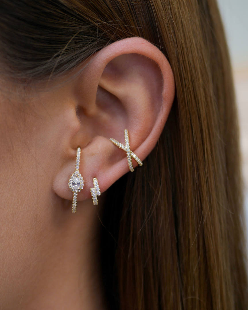 Earcuff Croisé Intemporel – Blanc en argent 925 rhodié, lignes entrelacées au design structuré et contemporain, finition polie brillante résistante à l’oxydation, format ajustable à clipser sans piercing, imaginé pour illuminer l’oreille d’une touche graphique et élégante, à porter seul ou en accumulation.