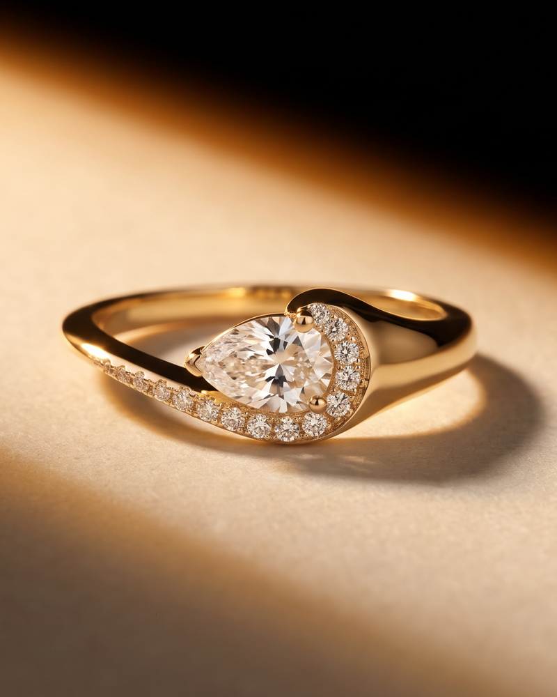 Bague « Pear Glow » en argent 925 rhodié, pierre centrale en zirconium taille poire entourée d’un délicat pavage de zirconiums, anneau légèrement torsadé à la finition polie brillante.