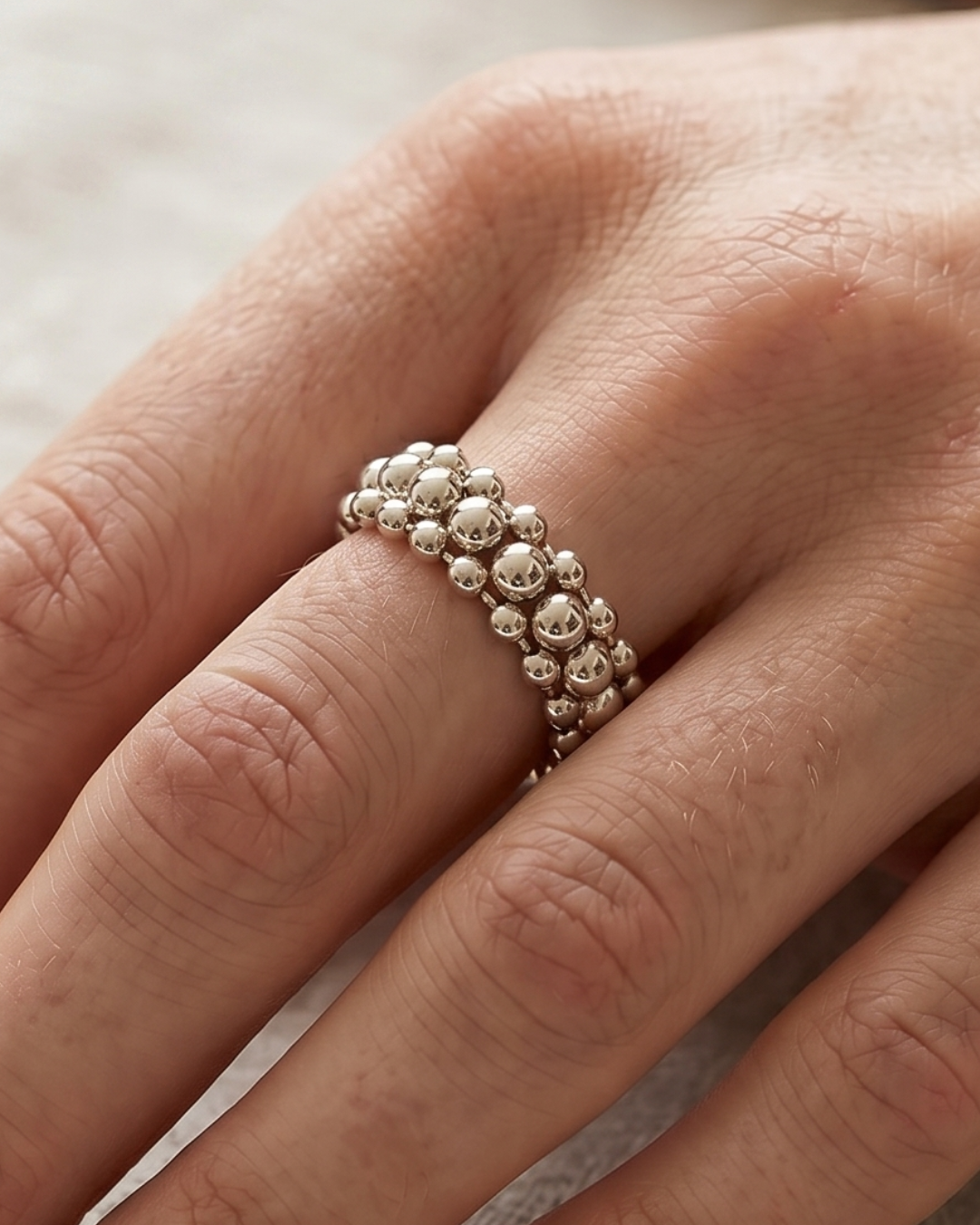Bague Perle Boost en argent 925, composée de plusieurs rangées ajourées de perles métalliques de différentes tailles.