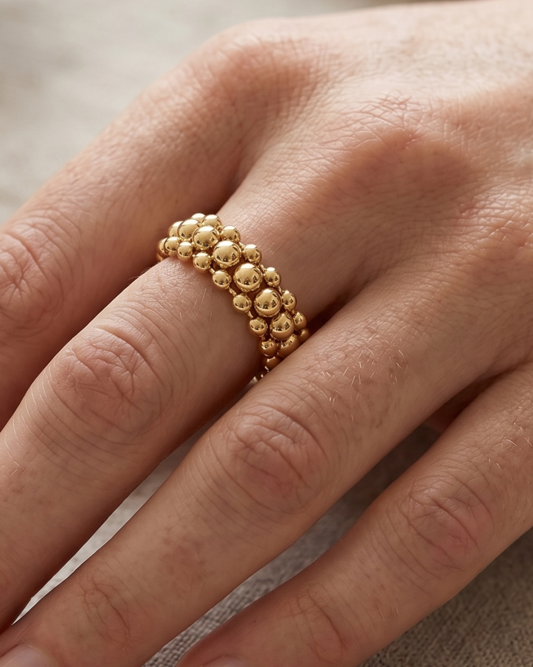 Bague Perle Boost en argent 925 doré a l'or jaune 18 carats, composée de plusieurs rangées ajourées de perles métalliques de différentes tailles.