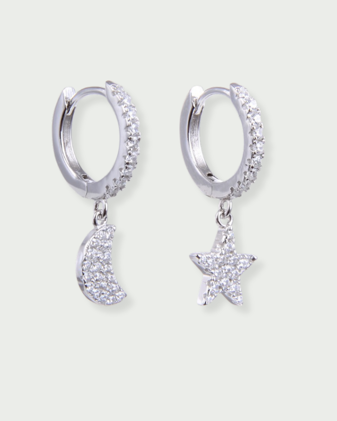 Boucles d’oreilles dormeuses « Céleste » en argent 925, un pendant lune pavé de zirconiums et un pendant étoile pavée de zirconiums, monture lisse finition polie brillante.