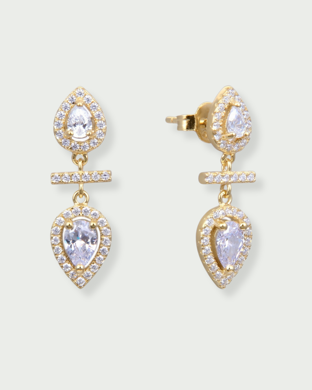 Boucles d’oreilles « Opposite Infini Poire » en argent 925 doré à l’or jaune 18 carats, deux zircons blancs taille poire montés en symétrie miroir séparés par une petite barre sertie, finition polie brillante.