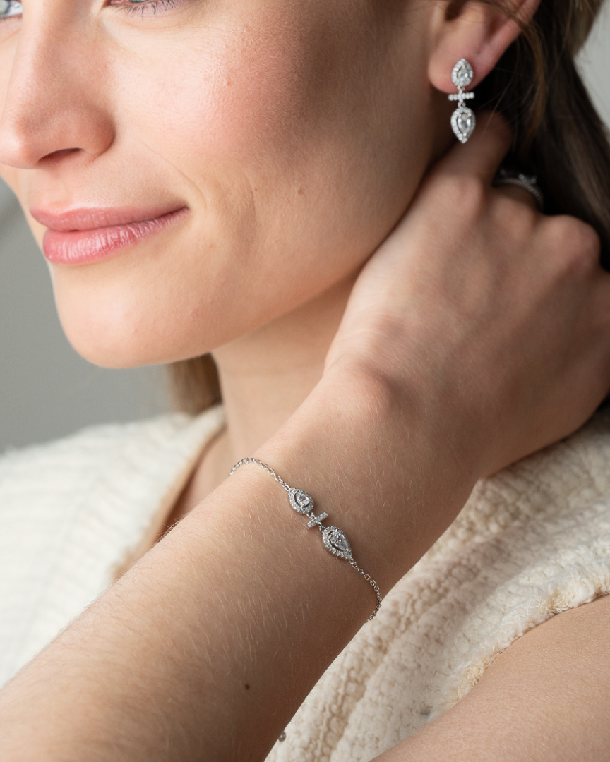 Boucles d’oreilles « Opposite Infini Poire » en argent 925 rhodié, deux zircons blancs taille poire montés en symétrie miroir, séparés par une petite barre sertie, finition polie brillante.