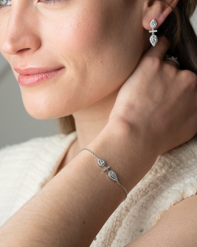 Boucles d’oreilles « Opposite Infini Poire » en argent 925 doré à l’or jaune 18 carats, deux zircons blancs taille poire montés en symétrie miroir séparés par une petite barre sertie, finition polie brillante.