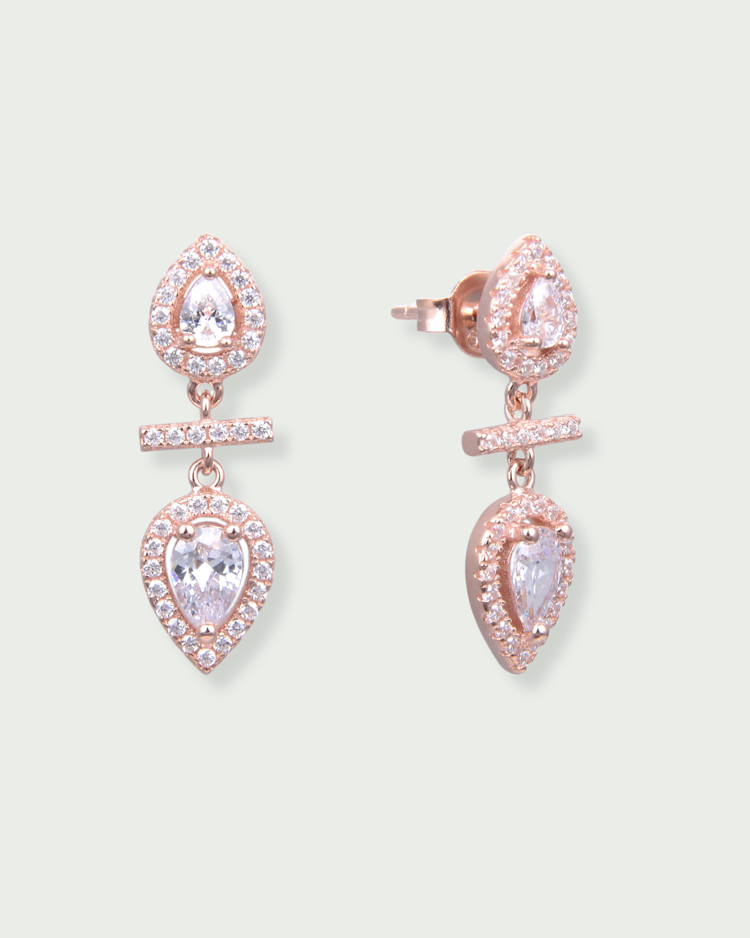 Boucles d’oreilles « Opposite Infini Poire » en argent 925 doré à l'or rose, deux zircons blancs taille poire montés en symétrie miroir, séparés par une petite barre sertie.