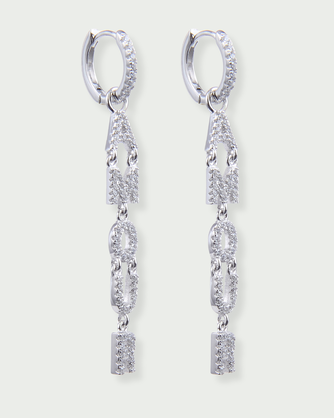 Boucles d’oreilles pendantes « Amour » en argent 925 rhodié, lettres serties de zirconiums formant le mot AMOUR suspendues à un anneau, finition polie brillante.