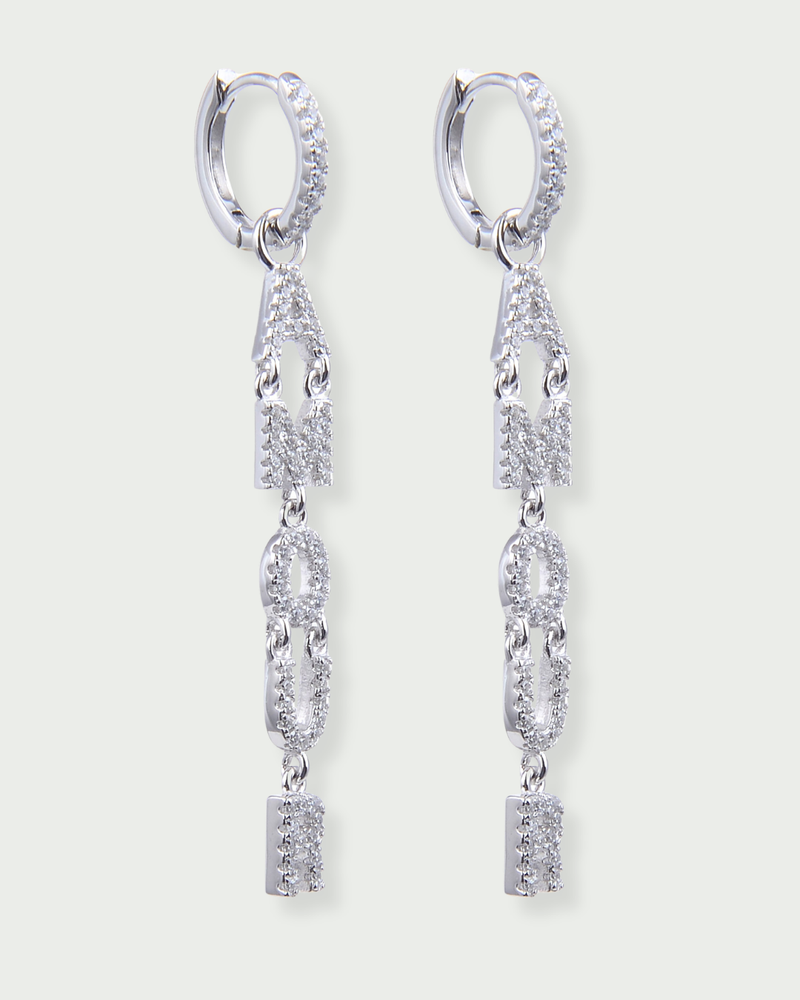 Boucles d’oreilles pendantes « Amour » en argent 925 rhodié, lettres serties de zirconiums formant le mot AMOUR suspendues à un anneau, finition polie brillante.