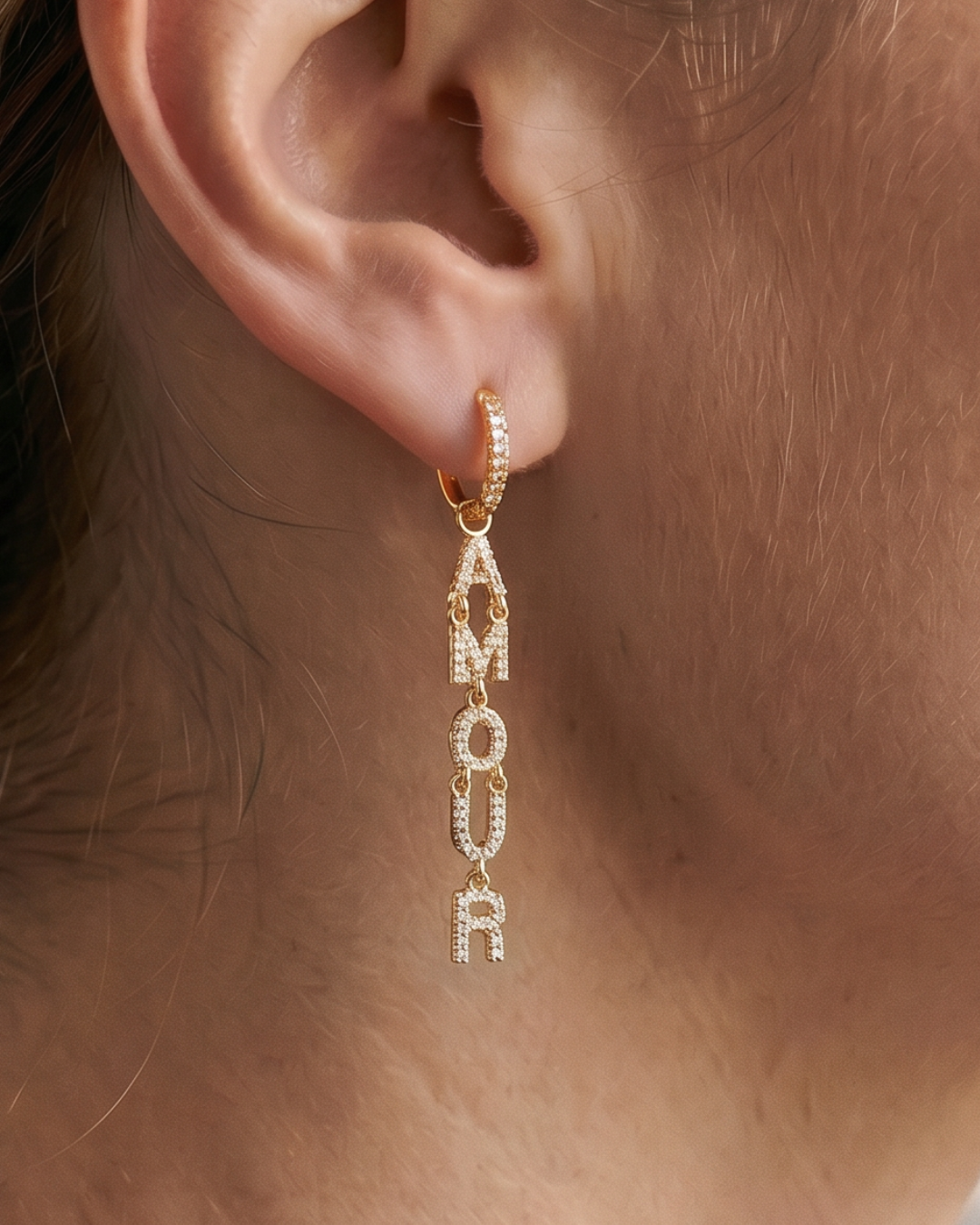 Boucles d’oreilles pendantes « Amour » en argent 925 doré à l’or fin 18 carats, lettres serties de zirconiums formant le mot AMOUR suspendues à un anneau, finition polie brillante.