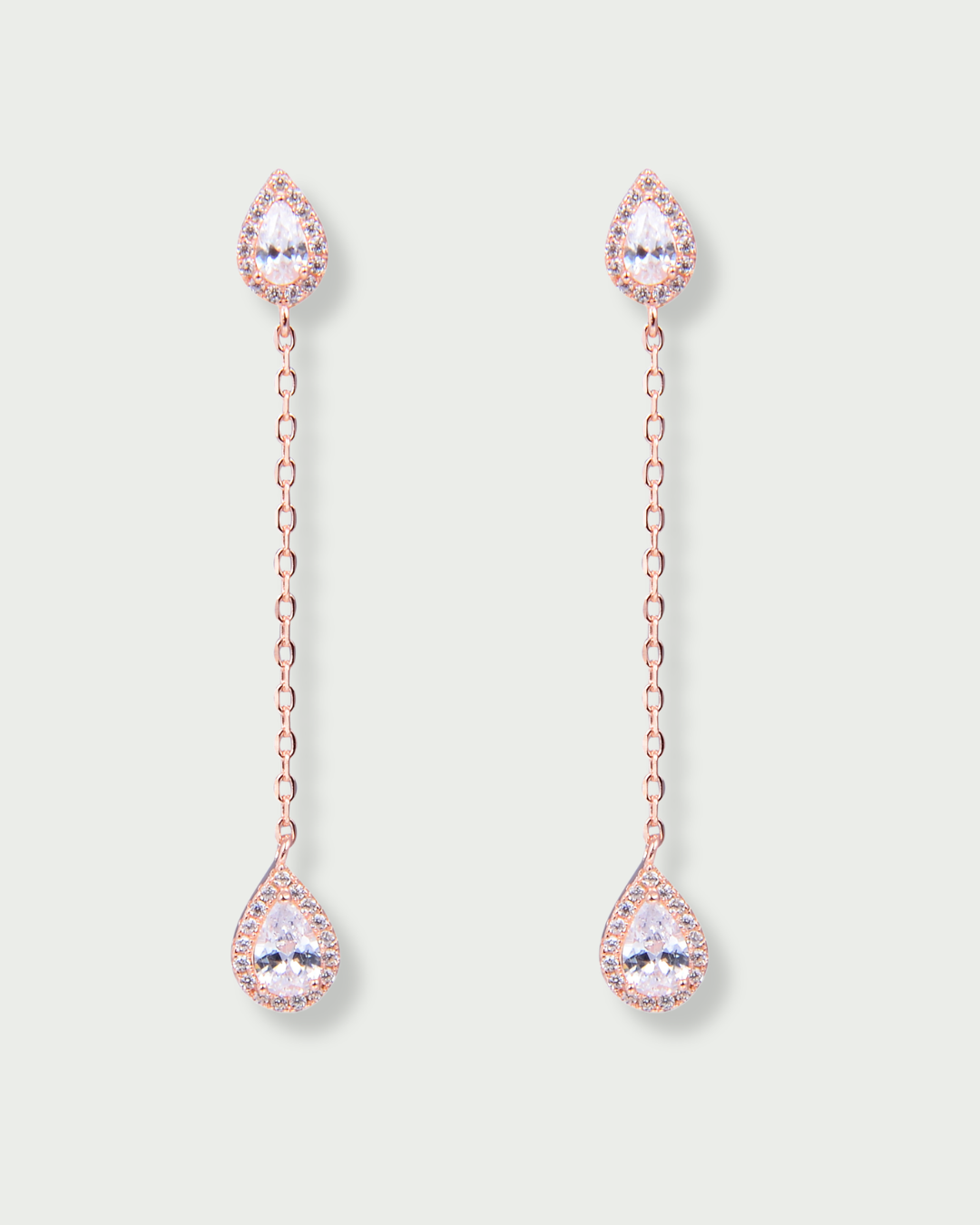 Boucles longues en argent 925 doré à l’or rose 18 carats, composées de deux zircons blancs taille poire délicatement reliés par une fine chaîne
