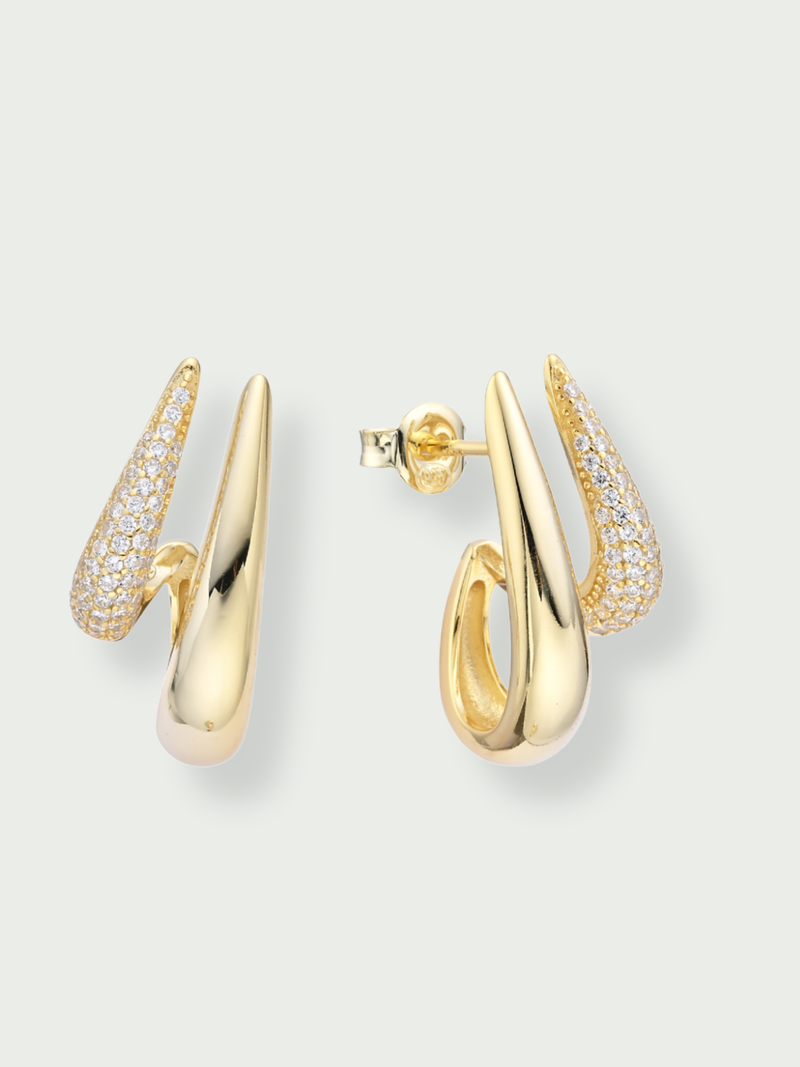 Boules d’oreilles Shape dorées en argent 925 plaqué or 18 carats avec pavage de zirconiums, design créole graphique et moderne qui enveloppe délicatement le lobe pour une silhouette sculpturale et lumineuse.