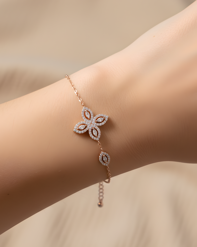 Bracelet « Fleur de Vie » en argent 925 doré à l’or rose 18 carats, motif central composé de quatre pierres en zirconium taille marquise formant une fleur, chaîne ajustable 15 + 3 cm, finition polie brillante.