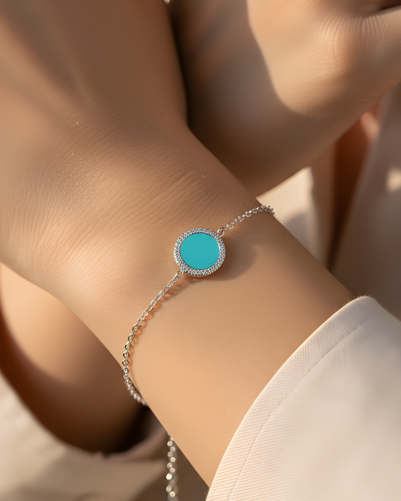 Bracelet en argent 925 rhodié, orné d’une petite médaille ronde sertie d’une pierre turquoise, finition polie brillante.