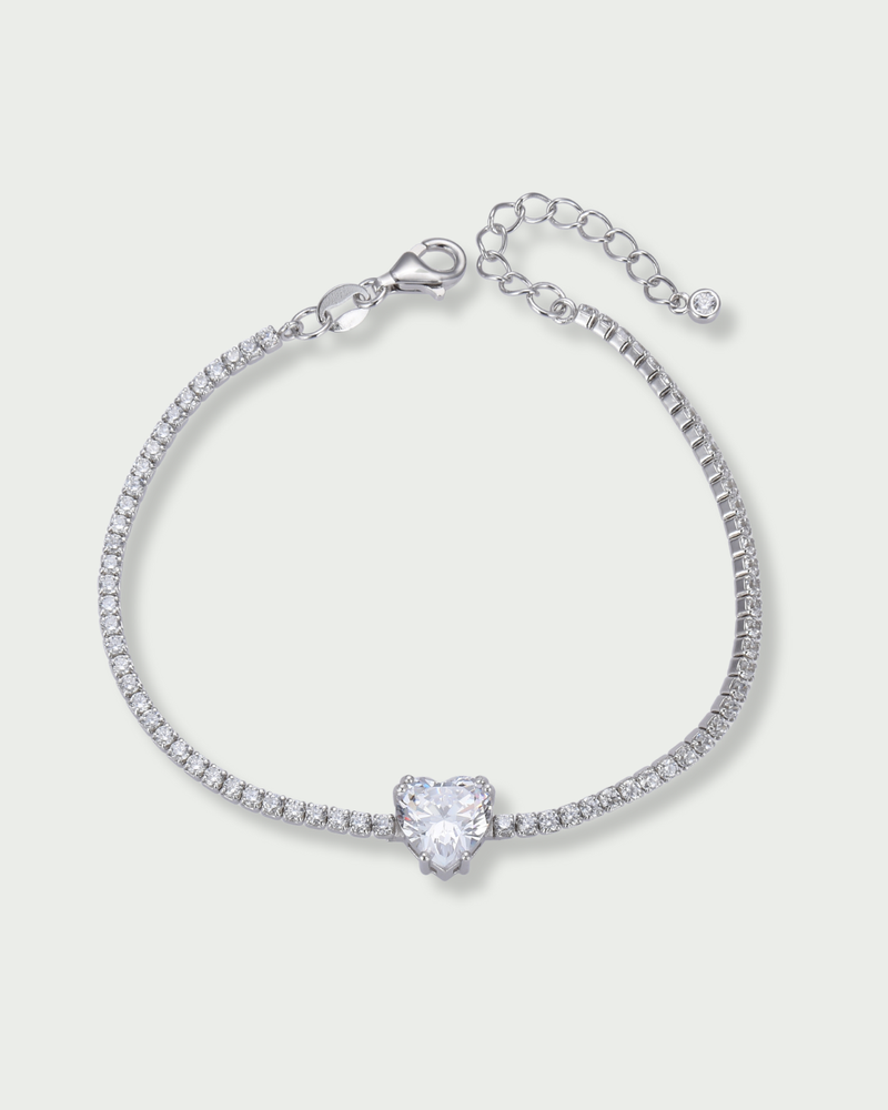 Bracelet Tennis Cœur Blanc en argent 925, composé d’une rivière de zirconiums blancs et orné d’un zirconium central en forme de cœur.