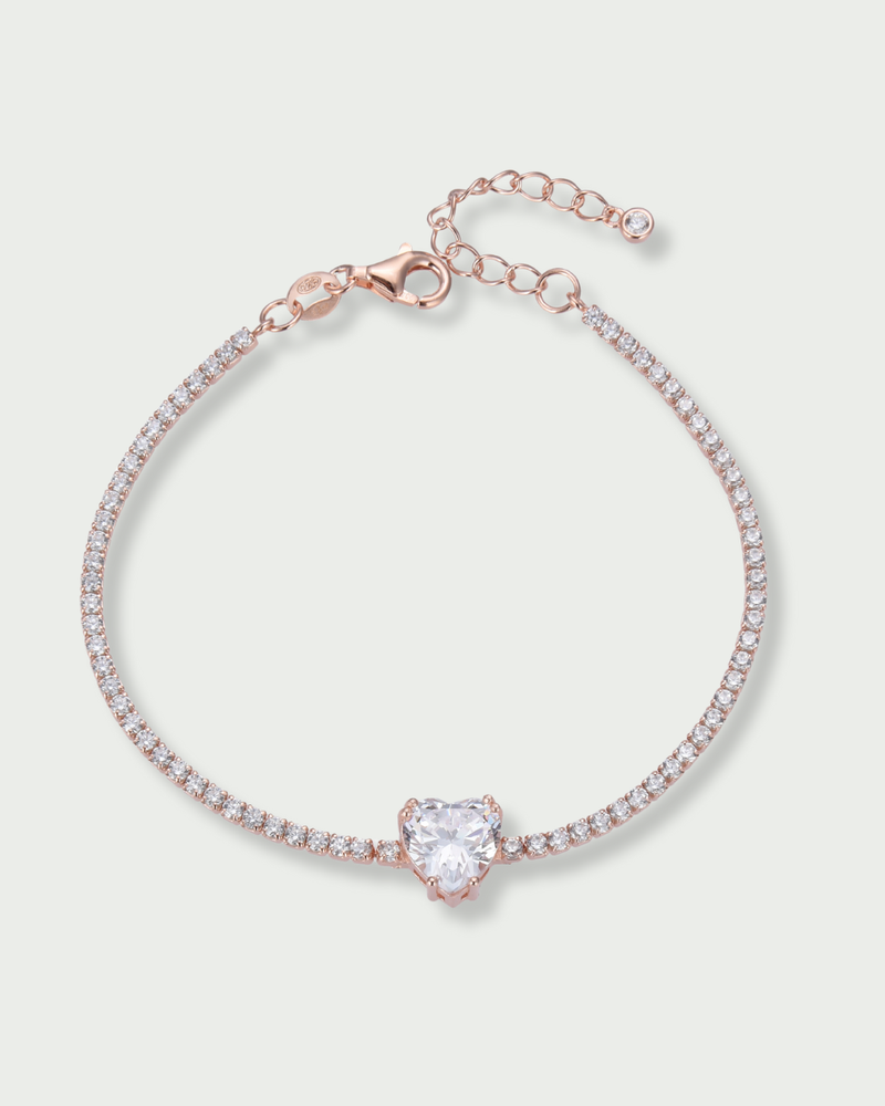Bracelet Tennis Cœur Blanc en argent 925 doré a l'or rose 18 carats, composé d’une rivière de zirconiums blancs et orné d’un zirconium central en forme de cœur.