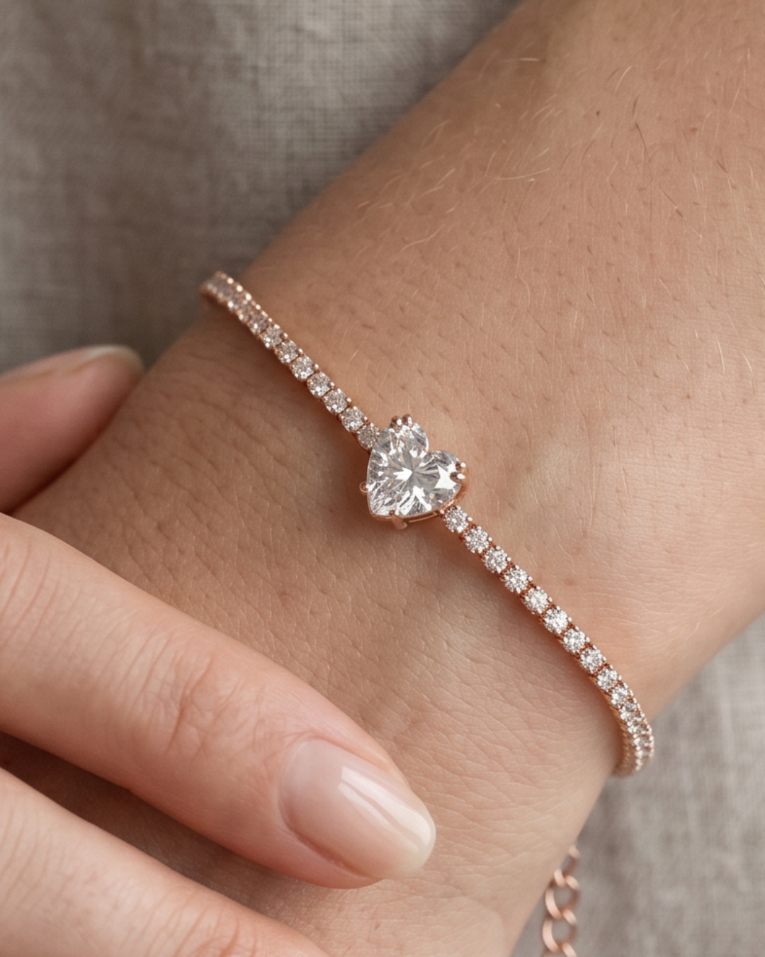 Bracelet Tennis Cœur Blanc en argent 925 doré a l'or rose 18 carats, composé d’une rivière de zirconiums blancs et orné d’un zirconium central en forme de cœur.