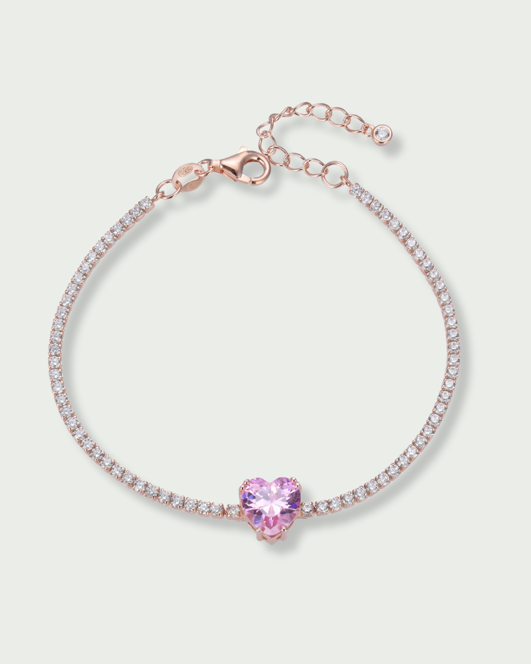 Bracelet Tennis Cœur Rose en argent 925 doré a l'or rose 18 carats, composé d’une rivière de zirconiums blancs et orné d’un zirconium rose central en forme de cœur.
