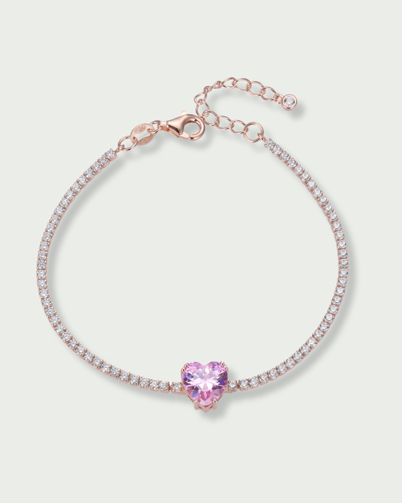 Bracelet Tennis Cœur Rose en argent 925 doré a l'or rose 18 carats, composé d’une rivière de zirconiums blancs et orné d’un zirconium rose central en forme de cœur.