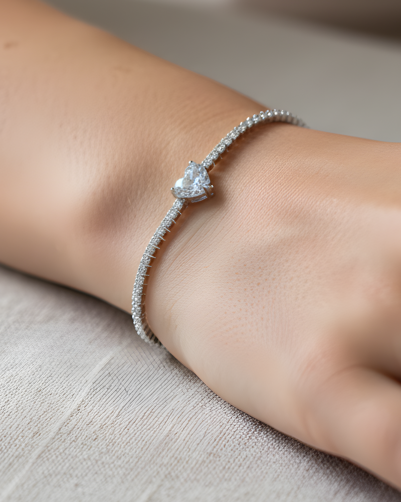 Bracelet « Tennis Cœur » en argent 925 rhodié, rangée continue de pierres blanches sublimée par un cœur de zirconium.