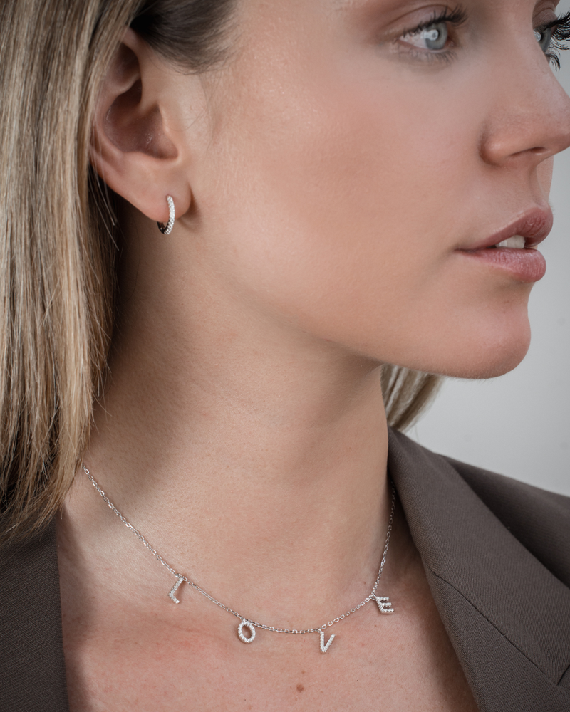 Collier « Love » en argent 925 rhodié, pendentif composé de lettres serties de zirconiums formant le mot LOVE, suspendu à une chaîne fine, finition polie brillante.