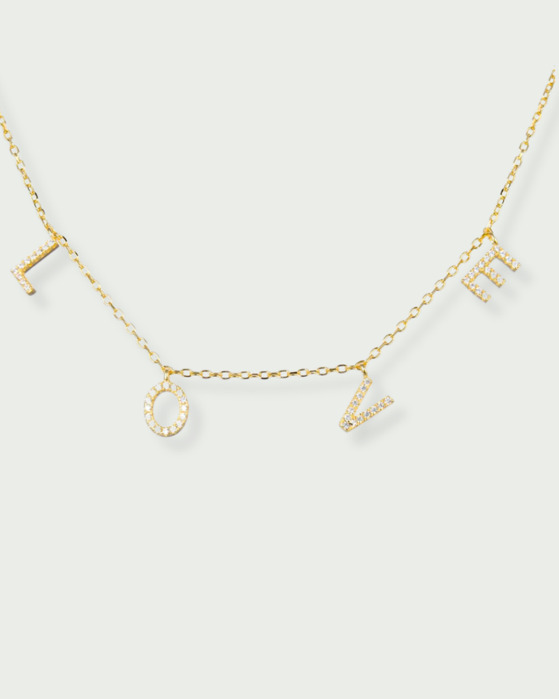 Collier « Love » en argent 925 doré à l’or fin 18 carats, pendentif composé de lettres serties de zirconiums formant le mot LOVE, suspendu à une chaîne fine, finition polie brillante.